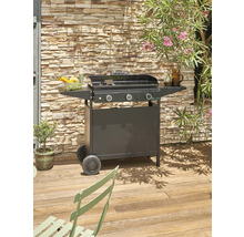 Photo d''extérieur d''un barbecue à gaz noir à trois brûleurs sur une terrasse en bois avec un mur de pierre en arrière-plan.