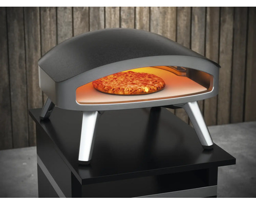 Pizzaofen mit Pizza im Inneren auf einem Tisch