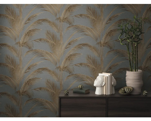 Wohnraum mit Palmenmuster-Tapete, Bücherstützen in Kopfform und Bambuspflanze im Topf auf einer Kommode.