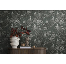 Gros plan d''un mur avec un papier peint à motifs de paons et de fleurs, avec une table et des décorations devant