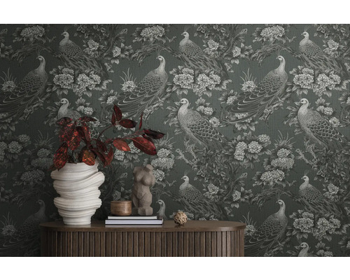 Gros plan d''un mur avec un papier peint à motifs de paons et de fleurs, avec une table et des décorations devant