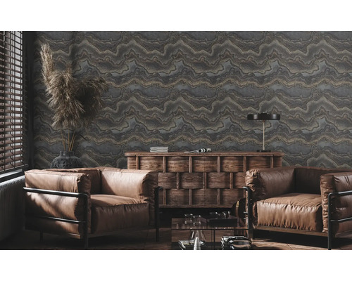 Wohnzimmer mit gemusterter Tapete, zwei Sesseln und Holzkommode.