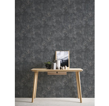 Szene mit einer grauen Strukturtapete und einem hellen Holztisch mit Dekoration