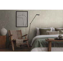 Schlafzimmer mit gemusterten Tapeten, Sessel und Bett