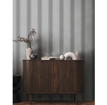 Commode en bois avec objets de décoration et papier peint rayé