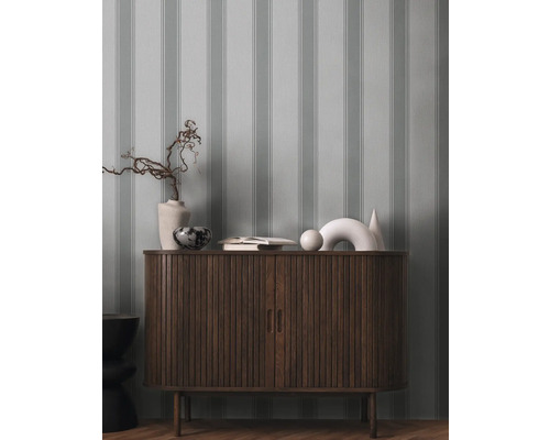 Commode en bois avec objets de décoration et papier peint rayé