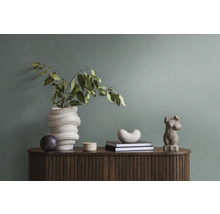 Dekoratives Interieur mit Vase, Skulpturen und Büchern auf einem Holzschrank