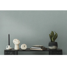 Dekorative Gegenstände wie Kerze, Skulptur, Uhr, Bücher und Topfpflanze auf einem Tisch