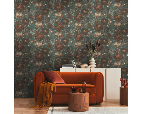 Un salon avec un papier peint à motifs floraux, un canapé, une table d''appoint et une commode.