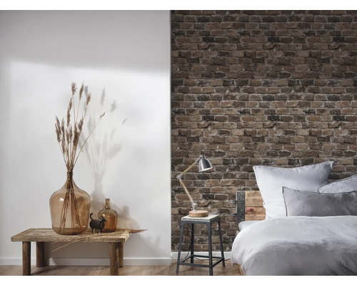 Dekoratives Zimmer mit Bett, Tisch, Lampe, Vase und Backsteintapete