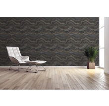 Wohnraum mit gemusterter Tapete, Sessel und Topfpflanze.