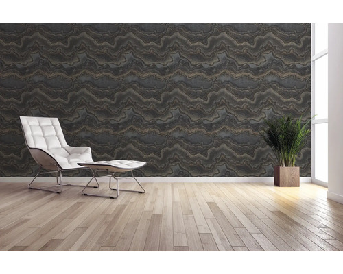 Wohnraum mit gemusterter Tapete, Sessel und Topfpflanze.