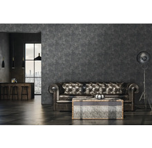 Wohnzimmer mit Ledersofa, Couchtisch und Stehlampe vor einer strukturierten Wand