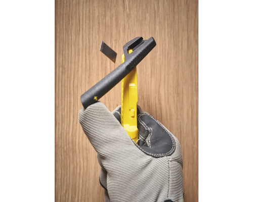 Messerwerkzeug mit Abbrechklinge in Hand mit Arbeitshandschuh vor Holzhintergrund