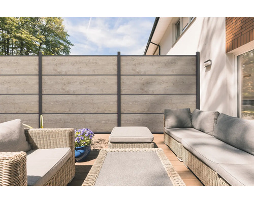 Terrasse mit Sichtschutzzaun, Lounge-Möbeln und Pflanztopf