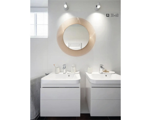Salle de bains moderne avec deux meubles sous-lavabo, miroir rond et carrelage blanc