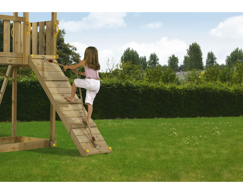 Fille grimpant sur une aire de jeux en bois avec une corde