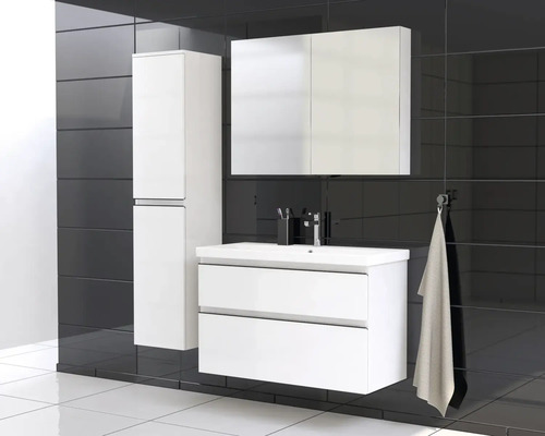 Salle de bains avec meuble sous-lavabo, armoire de toilette et armoire haute devant un mur noir.