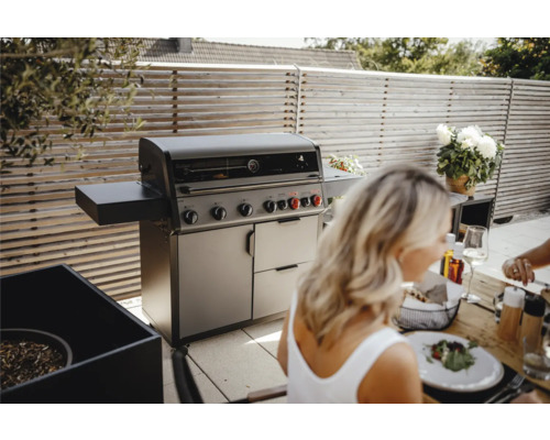 Barbecue à gaz à l''extérieur avec des personnes à table