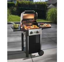 Grill mit Speisen auf dem Grillrost und Beilagen auf den Ablagetischen