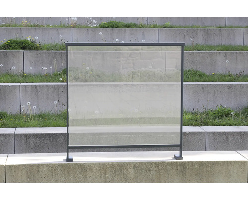 Windschutz aus Glas mit Metallrahmen vor einer Betontreppe