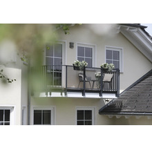 Aussenansicht eines Hauses mit Balkon, Balkonmöbeln und Blumenkästen