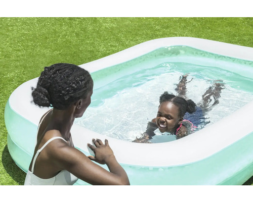 Mère et enfant dans une piscine gonflable dans le jardin