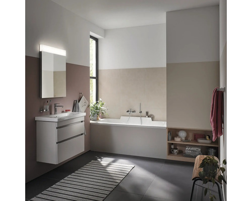 Salle de bain lumineuse avec meuble-lavabo, miroir, baignoire et étagère