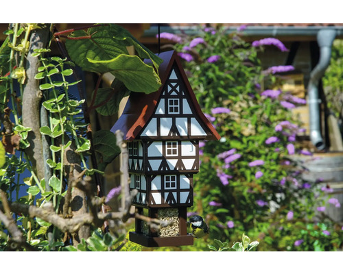 Vogelhaus im Fachwerkhausstil mit Futter und Meise