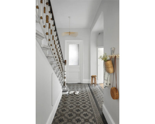 Heller Flur mit Treppe, Mosaikfliesen und dekorativen Elementen wie Lampe und Hängekörben.