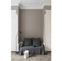 Intérieur élégant avec canapé, lampadaire et pile de livres devant un mur