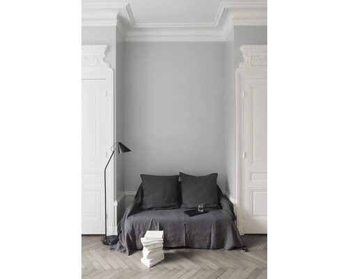 Vue intérieure avec canapé, lampadaire et pile de livres