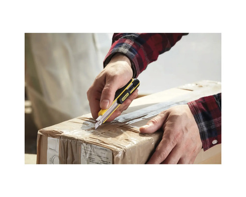 Eine Person öffnet einen Karton mit einem Teppichmesser der Marke Stanley.