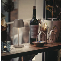 Lampe de table décorative à côté d''une bouteille de vin et de verres sur une étagère