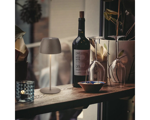 Lampe de table décorative à côté d''une bouteille de vin et de verres sur une étagère