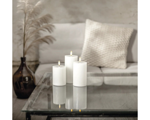 Trois bougies piliers blanches sur une table