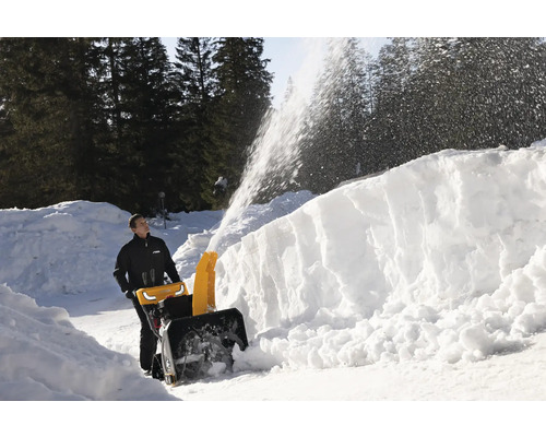 Mann benutzt eine Schneefräse zur Schneeräumung.