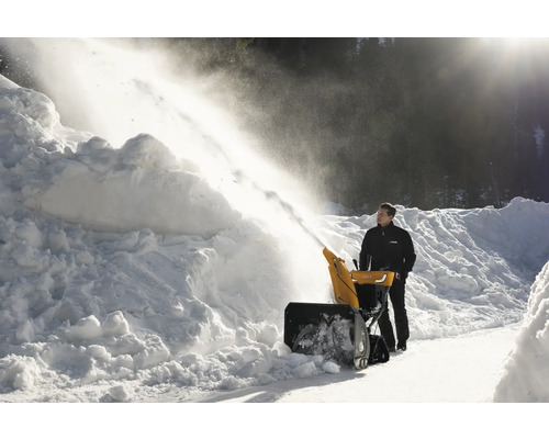 Mann benutzt eine Schneefräse zum Schneeräumen