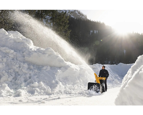 Mann benutzt Schneefräse zum Schneeräumen