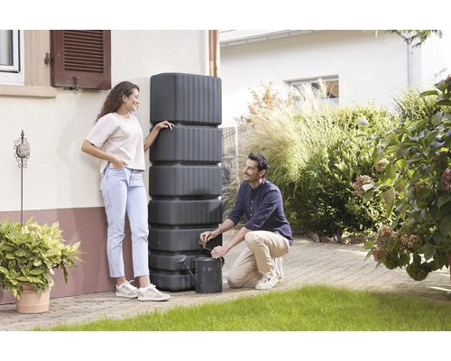 Regenwassertank zur Gartenbewässerung mit zwei Personen und einer Giesskanne