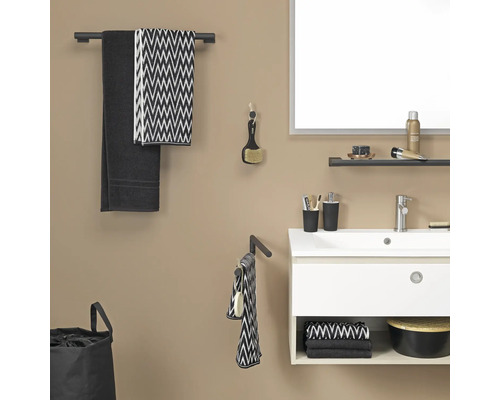 Badezimmer mit Waschbecken, Spiegel, Handtüchern und Badaccessoires