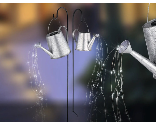 Dekorative Giesskannen mit Lichterketten auf Haken