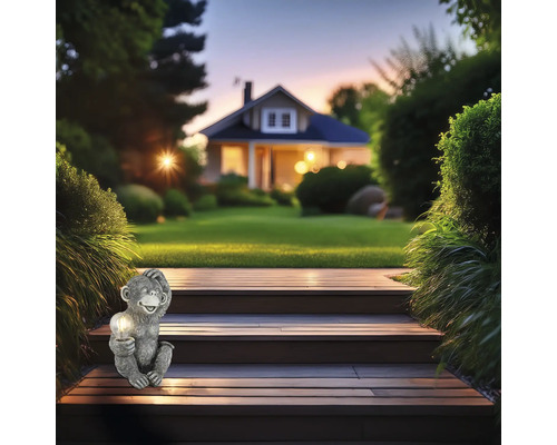 Szene mit einer Affenfigur mit Lampe auf einer Holztreppe im Garten vor einem Haus.