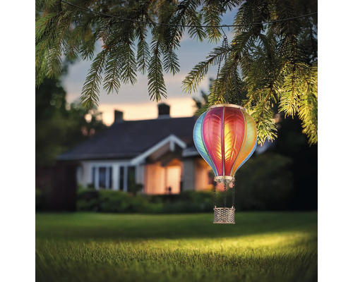 Dekorative Solarleuchte in Heissluftballonform hängt an einem Baum