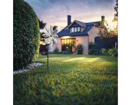 Gartenszene mit Blumensolarleuchte vor einem Wohnhaus