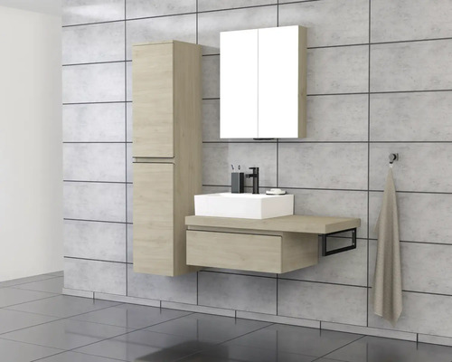 Badezimmer mit Waschtisch, Spiegelschrank und Hochschrank vor Fliesenwand