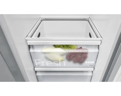 Detailaufnahme einer Kühlschrank-Gemüseschublade mit Salat und Trauben