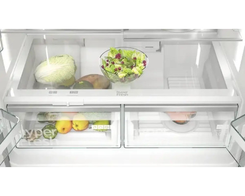 Kühlschrank Innenraum mit Gemüse und Salat in transparenten Behältern.