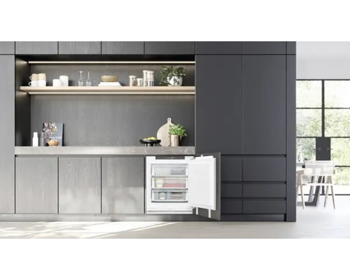 Moderne Küche mit grauem Design, Einbaukühlschrank, Regalen und Küchenutensilien.