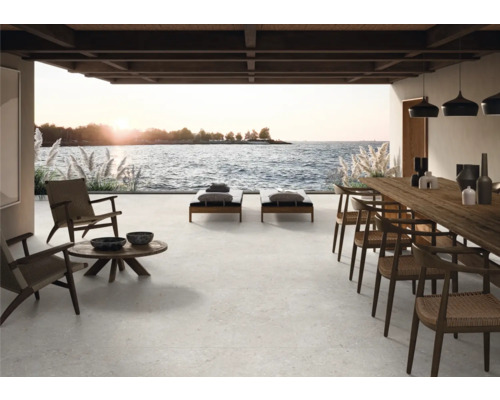 Terrasse avec mobilier de salon, chaises longues et table à manger avec vue sur la mer.